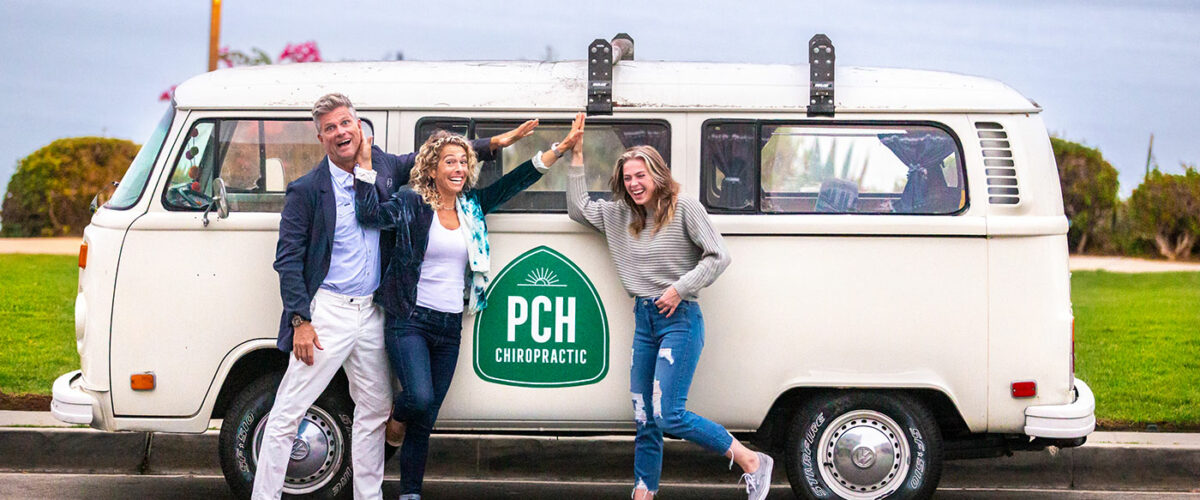 The Dana Point chiropractic team in front of their VW bus with the PCH logo on the side